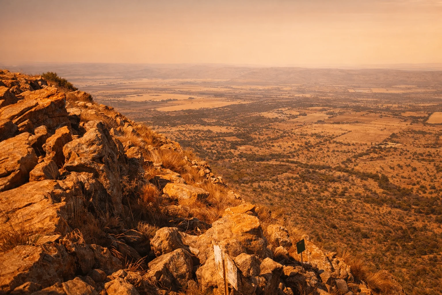 Hiker on a sandstone ridge above the Magaliesberg with sweeping valley views.